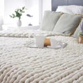 Person resting under chunky knit weighted blanket for sensory comfort and better sleep